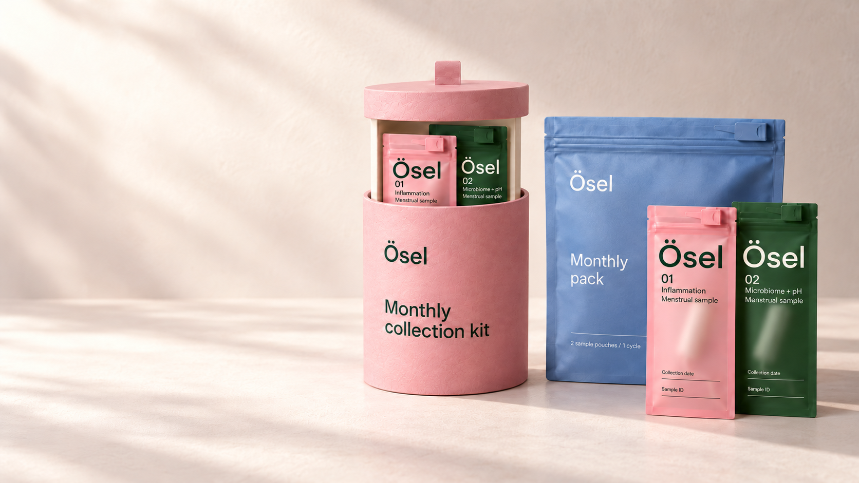 Ösel pink pull-out cylinder, frosted pink and forest green sample pouches, and a blue Monthly pack