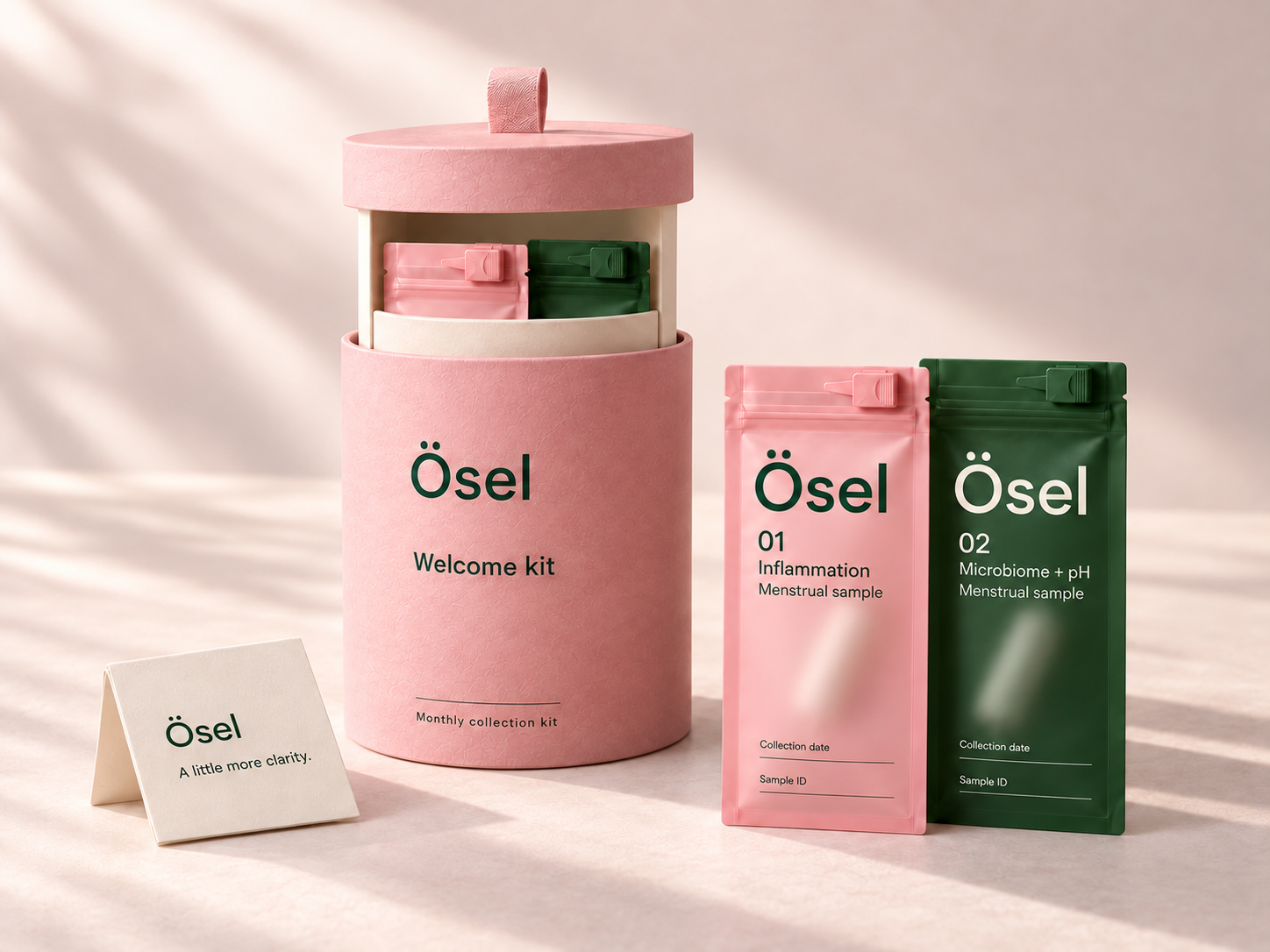 Pink Ösel welcome cylinder with its pull-out carrier, two frosted sample pouches, and a folded guide